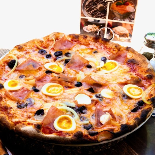 Tutto Pizza & Pasta's pizza with prosciutto, olives, onions, and sliced hard-boiled eggs.